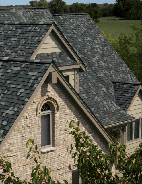 A close up view of a new roof on a light brown house